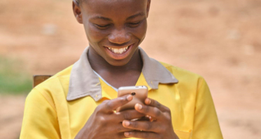 Boy in yellow shirt looking at phone